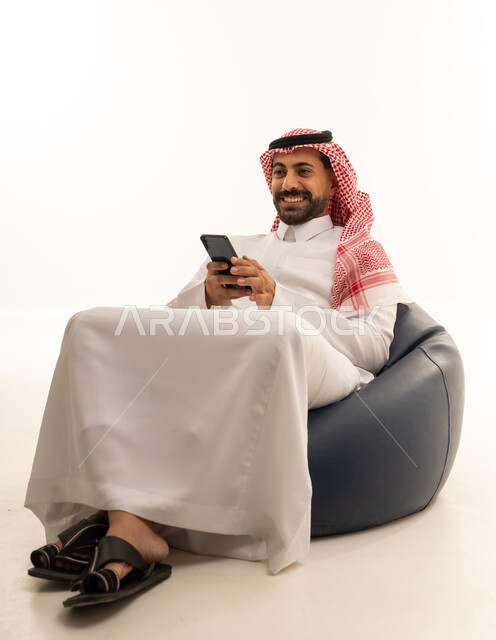 Saudi Man with Smartphone Sitting on Bean Bag