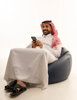 Saudi Man with Smartphone Sitting on Bean Bag