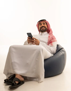 Saudi Man with Smartphone on Bean Bag Chair