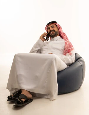 رجل سعودي يتحدث بالهاتف بالثوب التقليدي