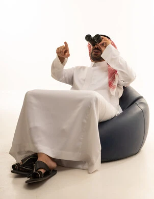 Saudi Man in Thobe Using Binoculars in Studio
