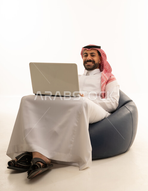 Saudi Man with Laptop on Blue Bean Bag