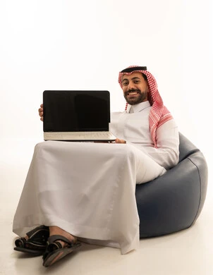 Saudi Man in Traditional Thobe Holding Laptop Studio