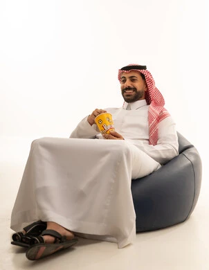 Saudi Man in Traditional Thobe Eating Popcorn