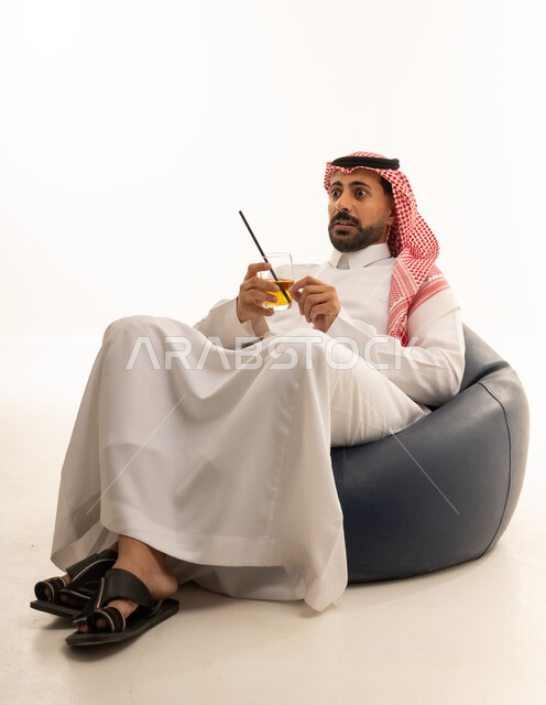 Surprised Saudi Man on Bean Bag with Drink