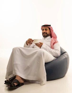 Saudi Man in Traditional Thobe Sitting with Coffee