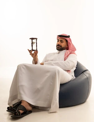 رجل سعودي مع ساعة رملية بخلفية بيضاء