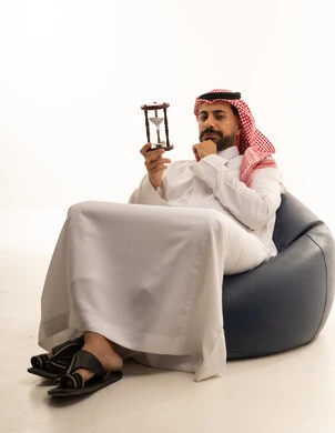 Saudi Man with Hourglass Thinking on Bean Bag