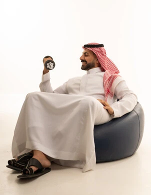 Saudi Man in Thobe Lifting Dumbbell on Bean Bag