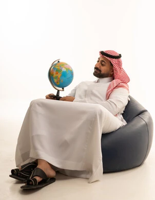 Saudi Man in Traditional Thobe Holding a Globe