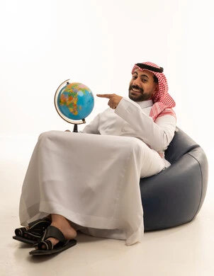 Saudi Man Pointing at Globe in Studio