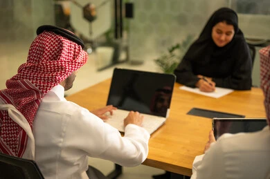 Management and division of tasks, a Saudi Gulf Arab team using advanced technical devices, integrating modern technologies into office work, developing projects and investments.