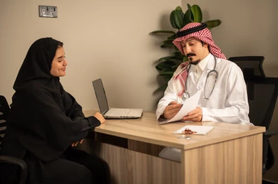 Study of working papers, project and investment development, use of laptops, two Arab Gulf Saudi employees conducting a business meeting inside the office, integrating modern technological devices with office work, managing and dividing tasks. Study of working papers, project and investment development, use of laptops, two Arab Gulf Saudi employees conducting a business meeting inside the office, integrating modern technological devices with office work, managing and dividing tasks.