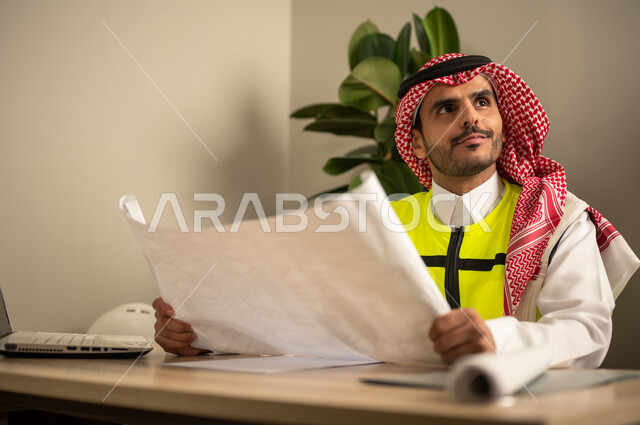 Development and evolution of work in the engineering field, architectural designs and plan verification, a Saudi Gulf Arab engineer wearing a safety coat holding a work plan, management of engineering projects, Saudi professions and jobs.