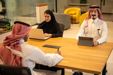 Gulf Arab Saudi employees use modern technological devices to accomplish work tasks, Saudi professions and jobs, achieve company goals, integrate work with advanced technology, and the Saudi work environment.