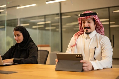 دمج العمل مع التكنولوجيا المتطورة، موظفين عربيين خليجيين سعوديين يستخدمون الاجهزة التقنية الحديثة، إنجاز مهام العمل ،مهن ووظائف سعودية، تحقيق أهداف الشركة، بيئة العمل السعودي.
