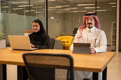 Saudi Arabian Gulf employees use modern technology to accomplish work tasks. Saudi Arabian jobs and professions, achieving company goals, Saudi work environment.