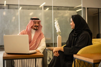 Achieving the company's goals, Saudi professions and jobs, discussing and explaining remote work tasks, Arab Gulf Saudi employees using modern technological devices, accomplishing work tasks, the Saudi work environment.