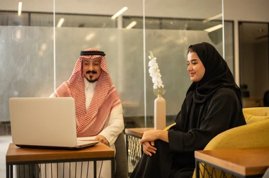 Saudi professions and jobs, achieving company goals, discussing and explaining remote work tasks, Arab Gulf Saudi employees using modern technological devices, completing work tasks, the Saudi work environment.