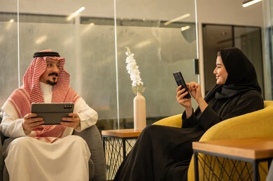Achieving the company's goals, Saudi professions and jobs, discussing and explaining remote work tasks, Arab Gulf Saudi employees using modern technological devices, accomplishing work tasks, the Saudi work environment.
