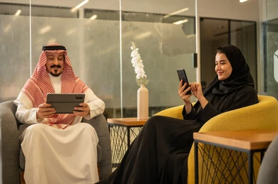 Saudi professions and jobs, achieving company goals, discussing and explaining remote work tasks, Arab Gulf Saudi employees using modern technological devices, completing work tasks, the Saudi work environment.