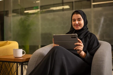 شركات ومكاتب خليجية في السعودية, جلسه عمل عن بعد، التركيز في إنجاز المهام، دمج التقنيات الحديثة بالمجال الإداري والمكتبي، امرأة عربية سعودية خليجية محجبة ترتدي العباءة السوداء تستخدم جهاز التابلت
