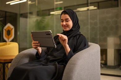شركات ومكاتب خليجية في السعودية, جلسه عمل عن بعد، التركيز في إنجاز المهام، دمج التقنيات الحديثة بالمجال الإداري والمكتبي، امرأة عربية سعودية خليجية محجبة ترتدي العباءة السوداء تستخدم جهاز التابلت