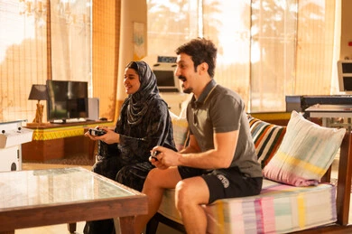 رجل وامرأة سعوديان يلعبان ألعاب الفيديو في المنزل