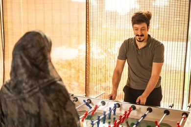 رجل سعودي يلعب كرة قدم الطاولة في الداخل