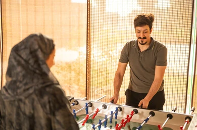 Saudi Couple Playing Foosball Table Indoors