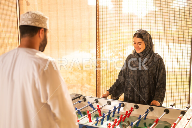 رجل وامرأة من سلطنة عمان يلعبان كرة الطاولة