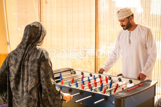 رجل وامرأة من عمان يلعبان فريرة كرة الطاولة