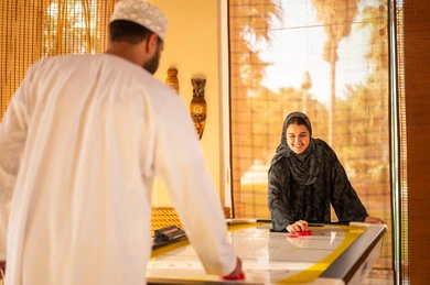 عمانيون يلعبون الهوكي الهوائي بالزي التقليدي