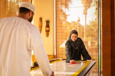 رجل وامرأة من عمان يلعبان هوكي الهواء