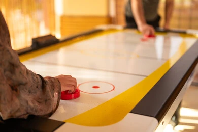 Woman in Abaya Playing Air Hockey Indoors