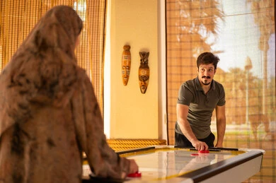Saudi Couple Playing Air Hockey in Recreation Room