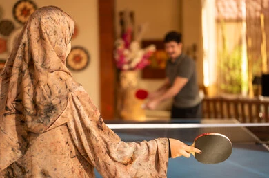 Saudi Woman in Abaya Playing Table Tennis Indoors