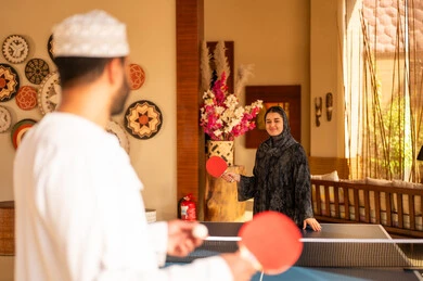 Omani Couple Playing Table Tennis in Traditional Attire