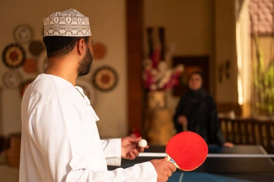 Omani Man Playing Table Tennis in Traditional Dress