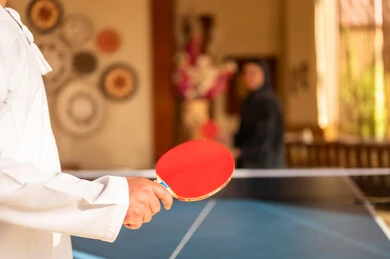 Saudi Man in Traditional Thobe Playing Table Tennis Indoor