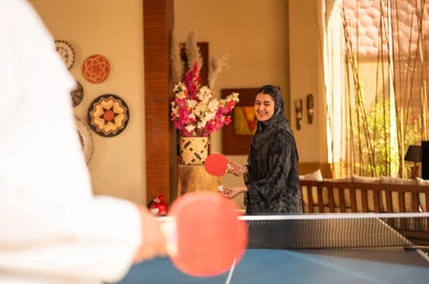 Saudi Woman Playing Table Tennis in Traditional Abaya