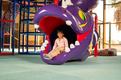 Saudi Boy Playing in Dragon Slide at Indoor Playground