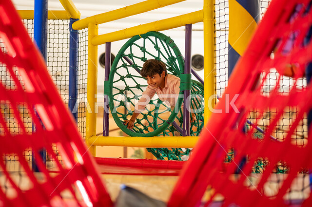 Arab Boy Playing in Indoor Soft Playground Structure