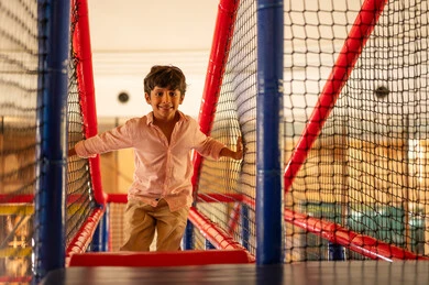 طفل عربي يلعب في منطقة ألعاب داخلية
