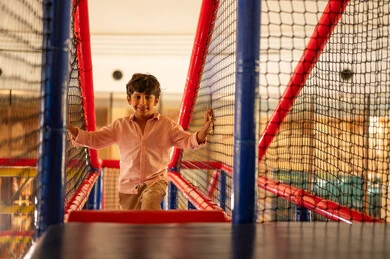طفل عربي يلعب في منطقة ألعاب داخلية للأطفال
