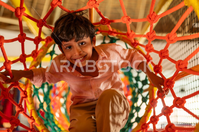 Saudi Boy Playing in Indoor Rope Tunnel Playground