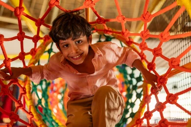 طفل سعودي يلعب في نفق الحبال في منطقة ألعاب