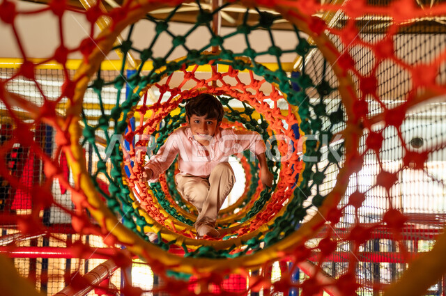 Arab Boy Playing in Colorful Net Tunnel