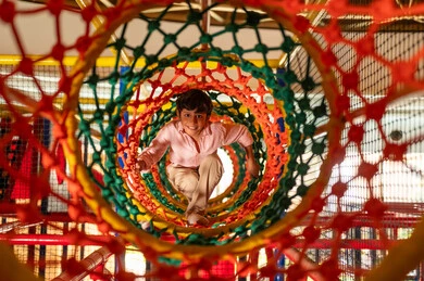 طفل عربي يلعب في نفق شبكي ملون