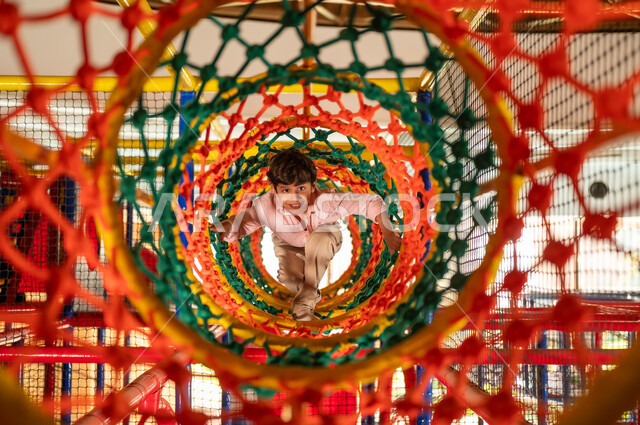 Saudi Boy Playing in Colorful Rope Mesh Tunnel